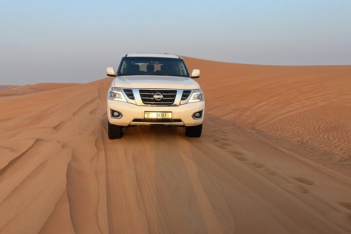 Experience the stunning Red Dunes as your safari vehicle navigates the endless sands bringing a sense of adventure and wonder to your Dubai desert exploration. Enjoy the ride!